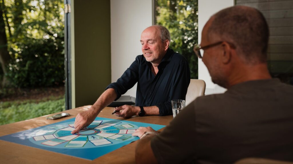 Arjan Blanken wijst aan tafel naar de beelden